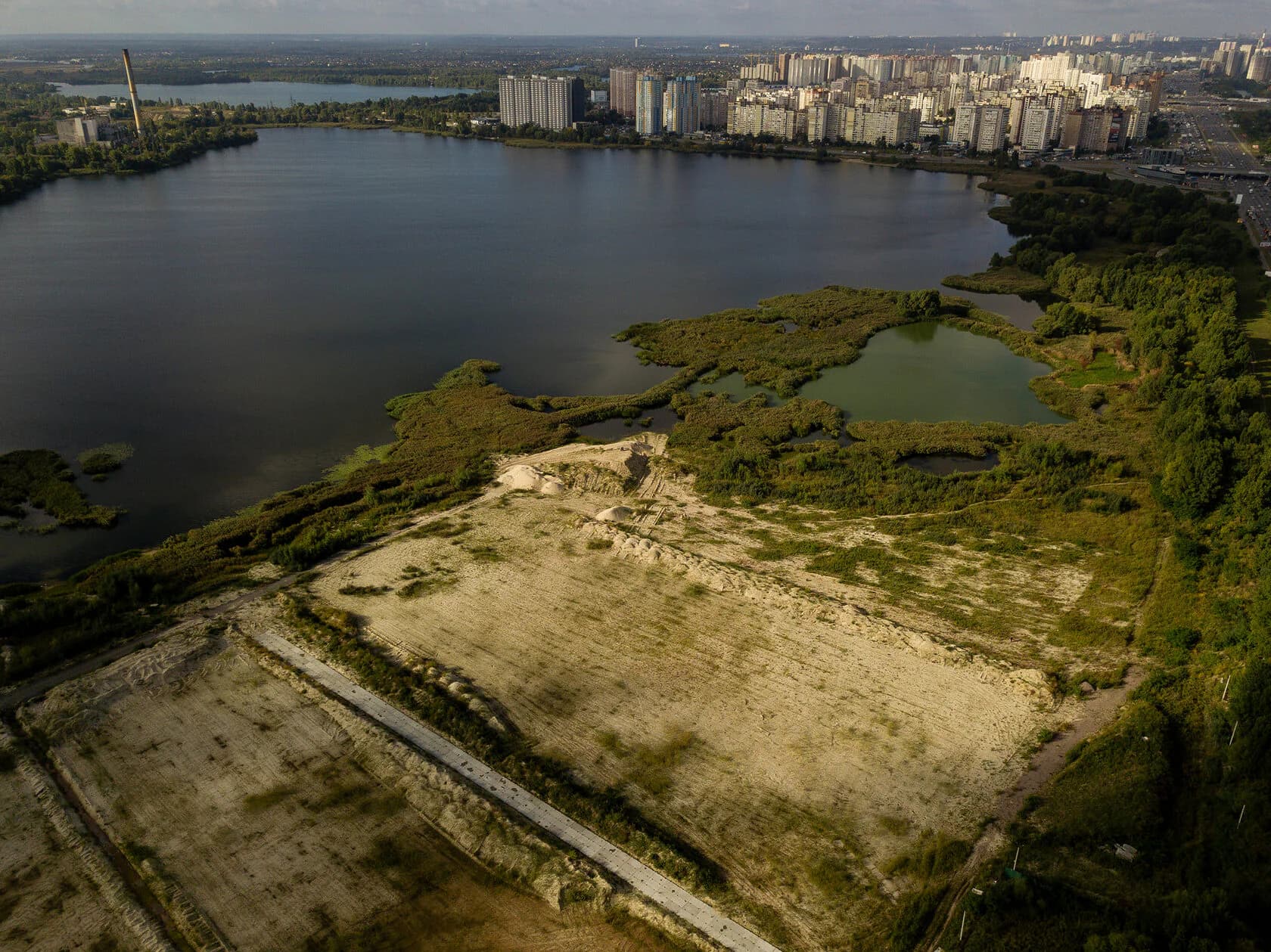 Озеро із засипаною піском ділянкою, підготовленою для забудови.