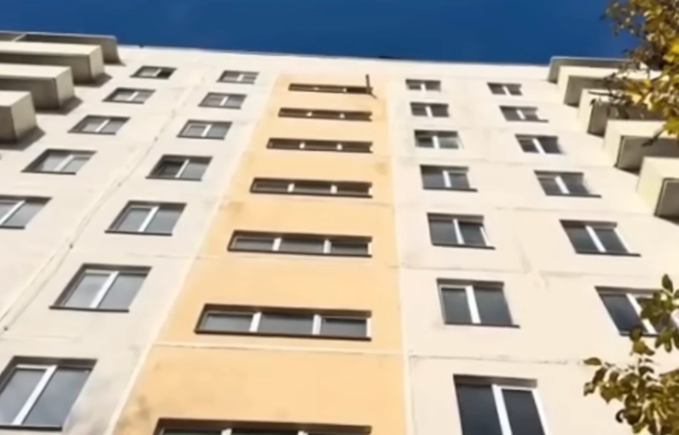 Труба, що стирчить з вікна сходової клітки. Скріншот: відео на Youtube «"Відновлення Маріуполя немає! Це обман! Ми бездомні вже 3 роки!" Крик душі мешканців Маріуполя»
