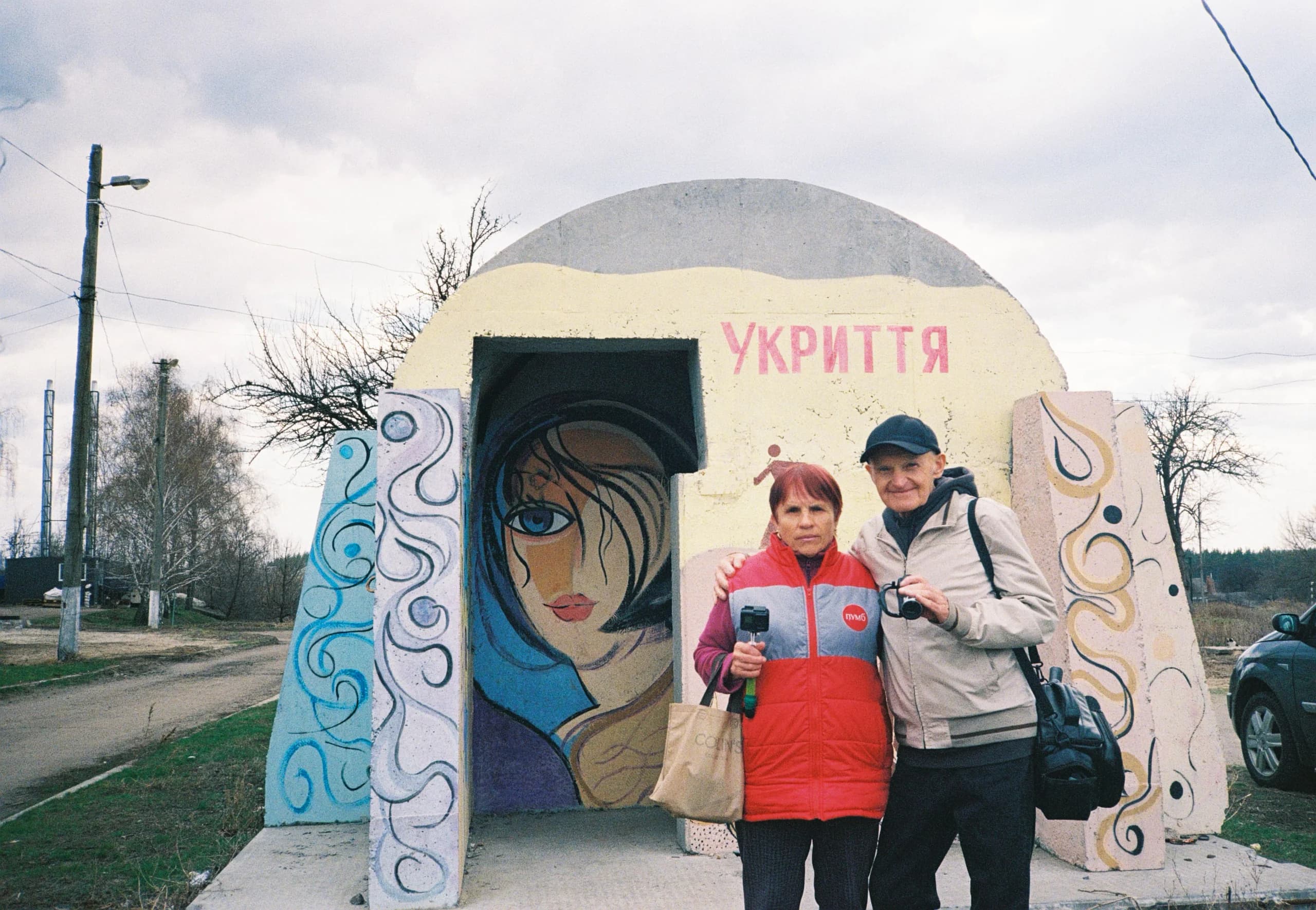 Анатолій Гарагатий зі своєю дружиною Наталею на тлі одного з розмальованих укриттів у Савинцях